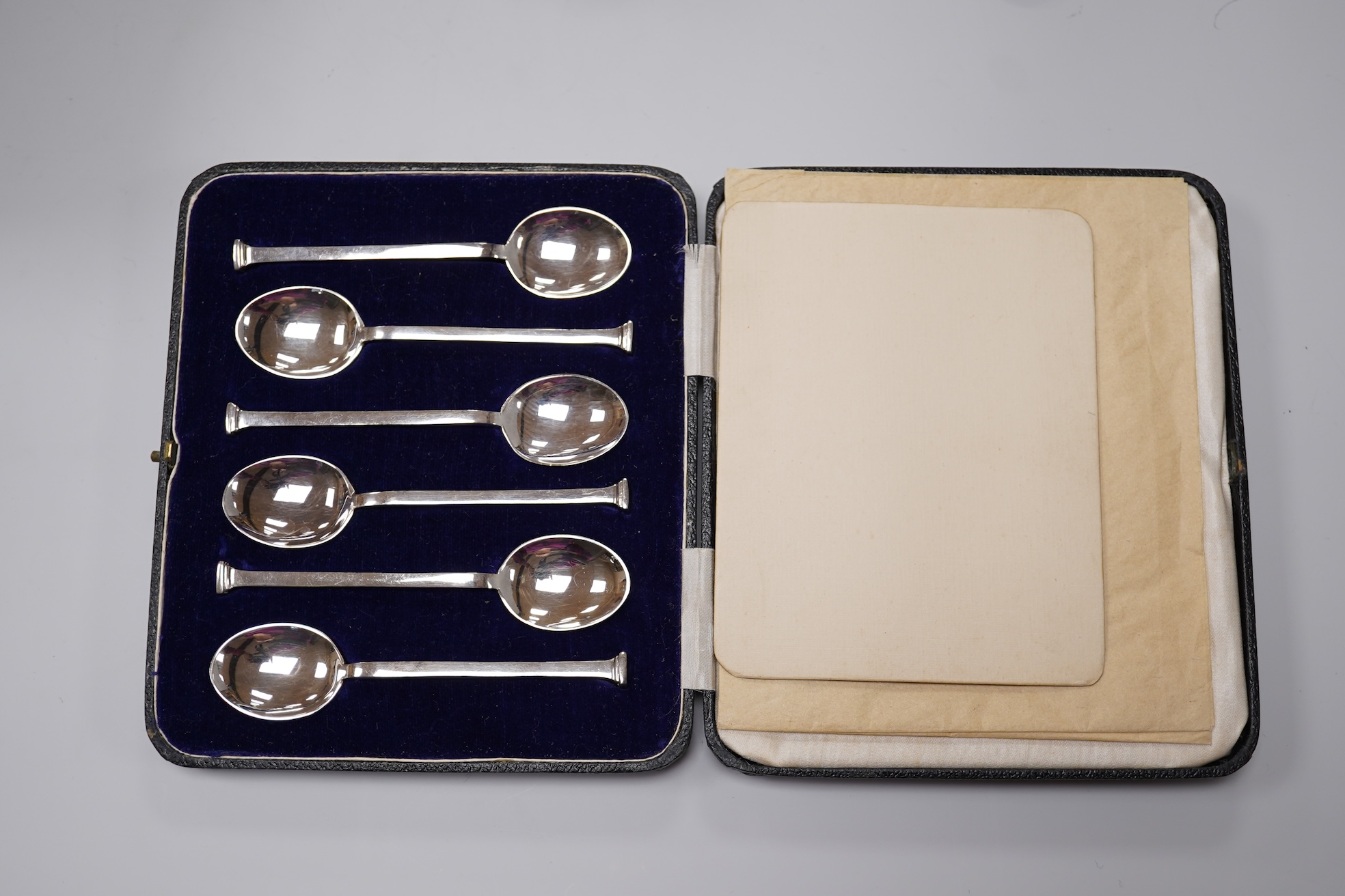 A George V silver Corinthian column candlestick, Birmingham, 1913, 16.1cm, a cased set of silver silver coffee spoons, two cased plated sets and a silver handled steel butter knife.